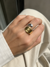 Anillo Nakoa bicolor ajustable puesto en la mano, con piezas martilladas en acabado dorado y plateado de BRAVATA.