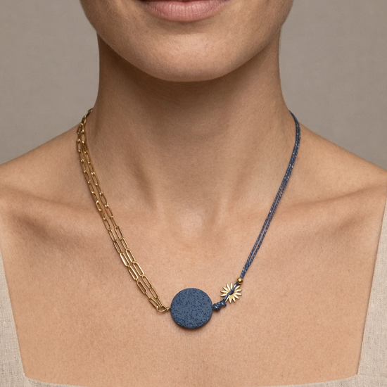 Mujer con collar de cadena dorada y cordón azul con piedra volcánica diseño moderno y original