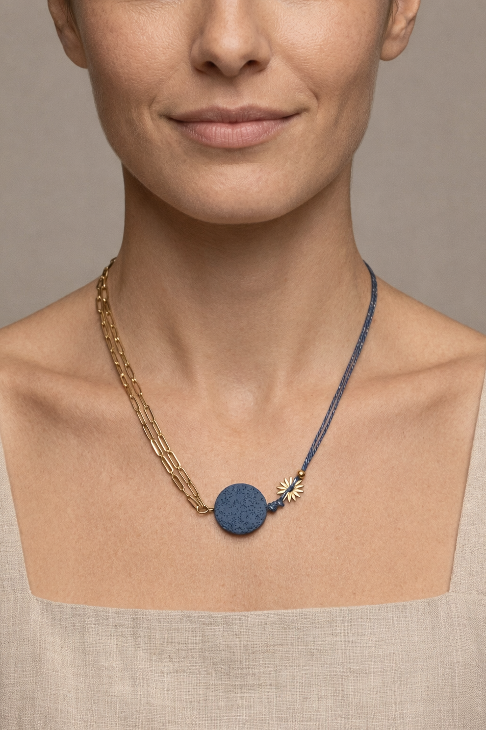 Mujer con collar de cadena dorada y cordón azul con piedra volcánica diseño moderno y original