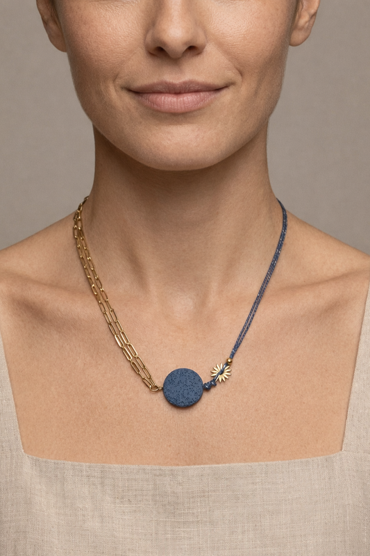 Mujer con collar de cadena dorada y cordón azul con piedra volcánica diseño moderno y original
