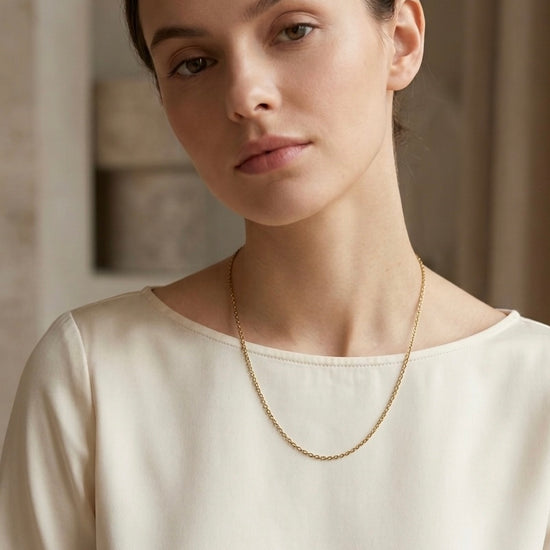 Collar de cadena fina dorada minimalista sobre mujer