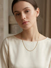 Collar de cadena fina dorada minimalista sobre mujer