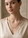 Collar de cadena fina plateada minimalista sobre mujer