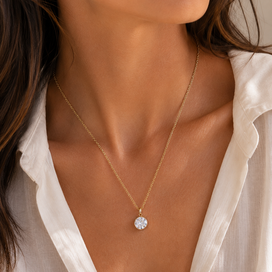 Mujer llevando collar dorado con circonita redonda brillante de BRAVATA