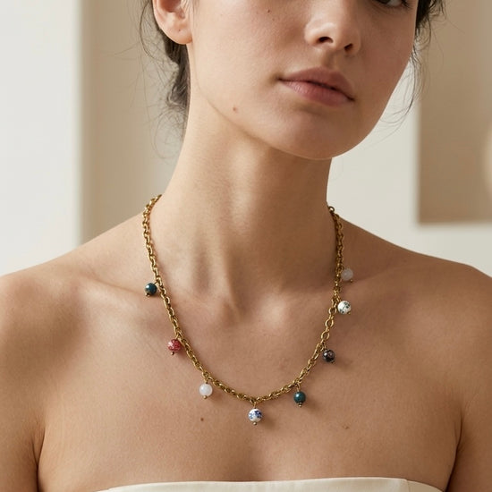 Mujer con collar dorado con colgantes de colores Bravata
