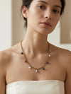 Mujer con collar dorado con colgantes de colores Bravata