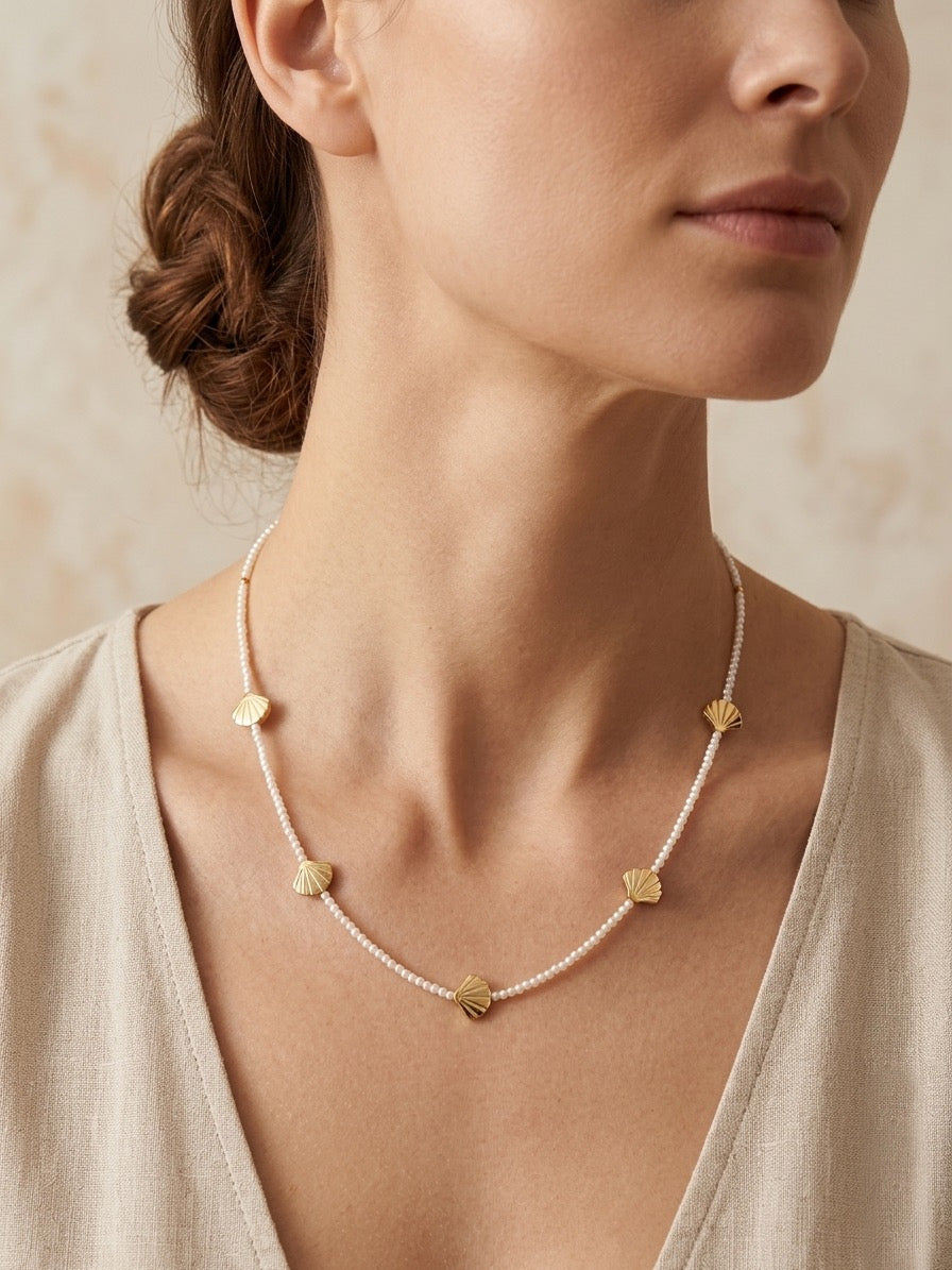 Collar con perlas y conchas doradas puesto en mujer estilo elegante y veraniego Bravata