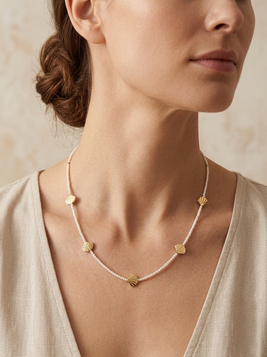 Collar con perlas y conchas doradas puesto en mujer estilo elegante y veraniego Bravata