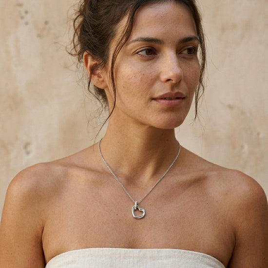 Mujer con collar plateado con colgante de corazón diseño elegante y minimalista