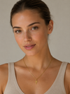 Mujer con collar de cruz dorado minimalista con cadena fina