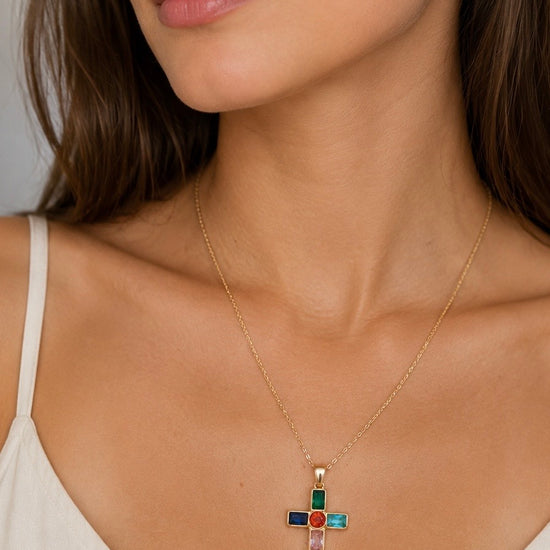 Mujer llevando collar dorado con cruz multicolor de BRAVATA
