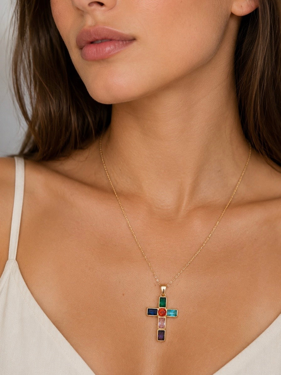 Mujer llevando collar dorado con cruz multicolor de BRAVATA