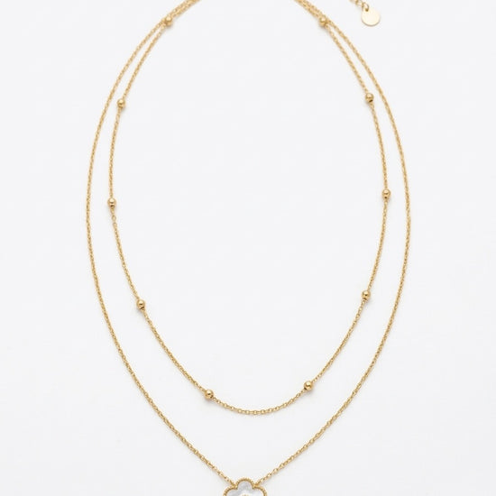 collar dorado de doble cadena con colgante de flor blanca y detalle central brillante