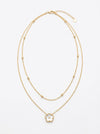 collar dorado de doble cadena con colgante de flor blanca y detalle central brillante