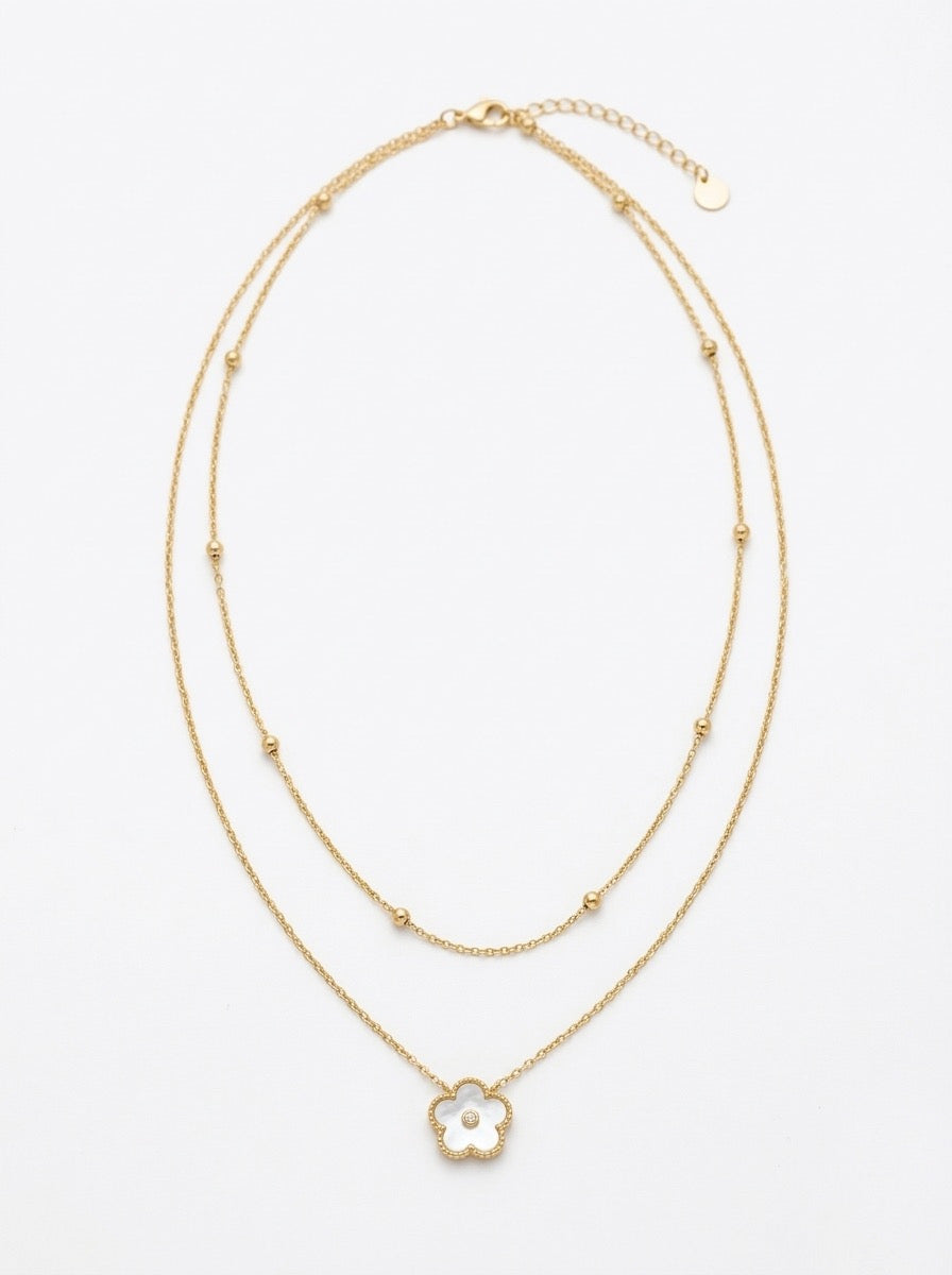collar dorado de doble cadena con colgante de flor blanca y detalle central brillante