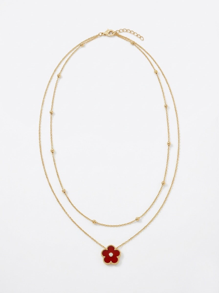 collar dorado de doble cadena con colgante de flor roja y detalle central brillante
