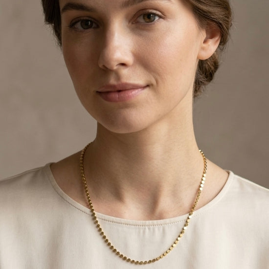 Collar fino dorado minimalista sobre mujer con estilo elegante