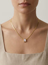 Mujer con collar dorado minimalista con piedra blanca rectangular