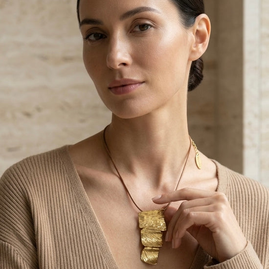 Mujer con collar dorado texturizado elegante Bravata
