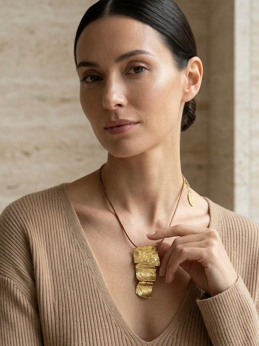 Mujer con collar dorado texturizado elegante Bravata