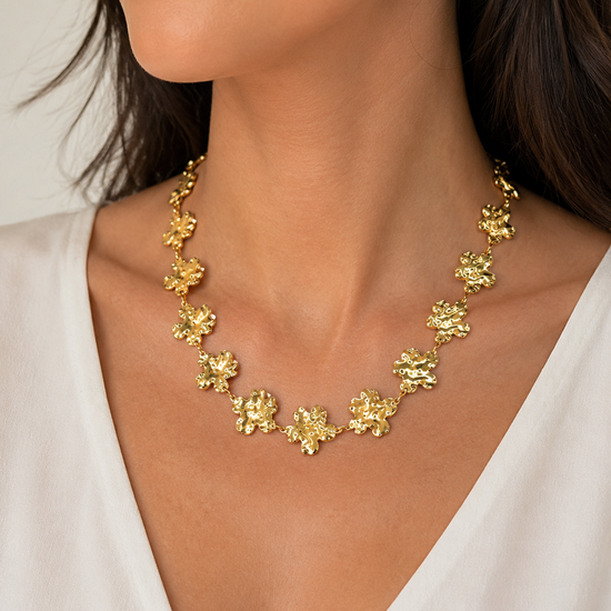 Modelo llevando el Collar Fiorella dorado con flores irregulares y acabado texturizado de BRAVATA.