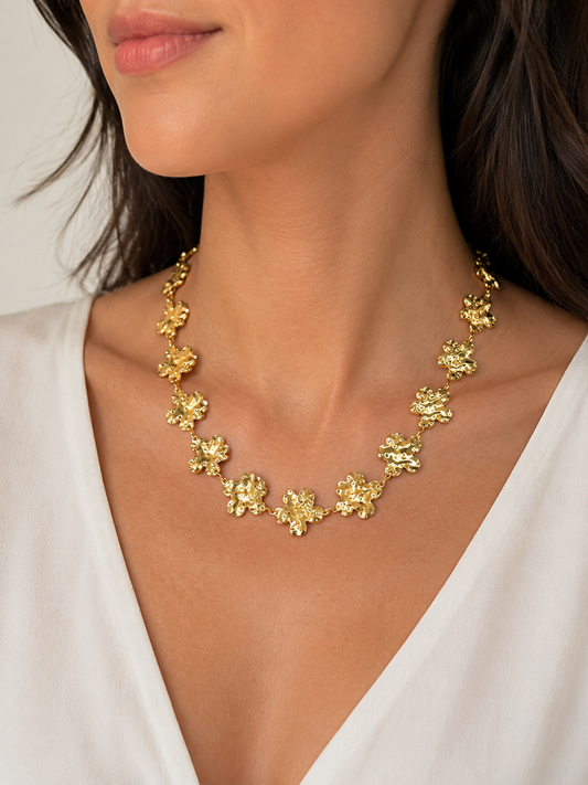 Modelo llevando el Collar Fiorella dorado con flores irregulares y acabado texturizado de BRAVATA.