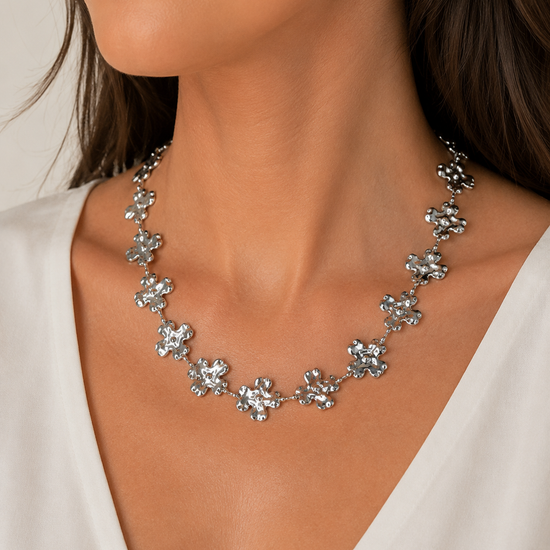 Modelo llevando el Collar Fiorella plateado con flores irregulares y acabado texturizado de BRAVATA.