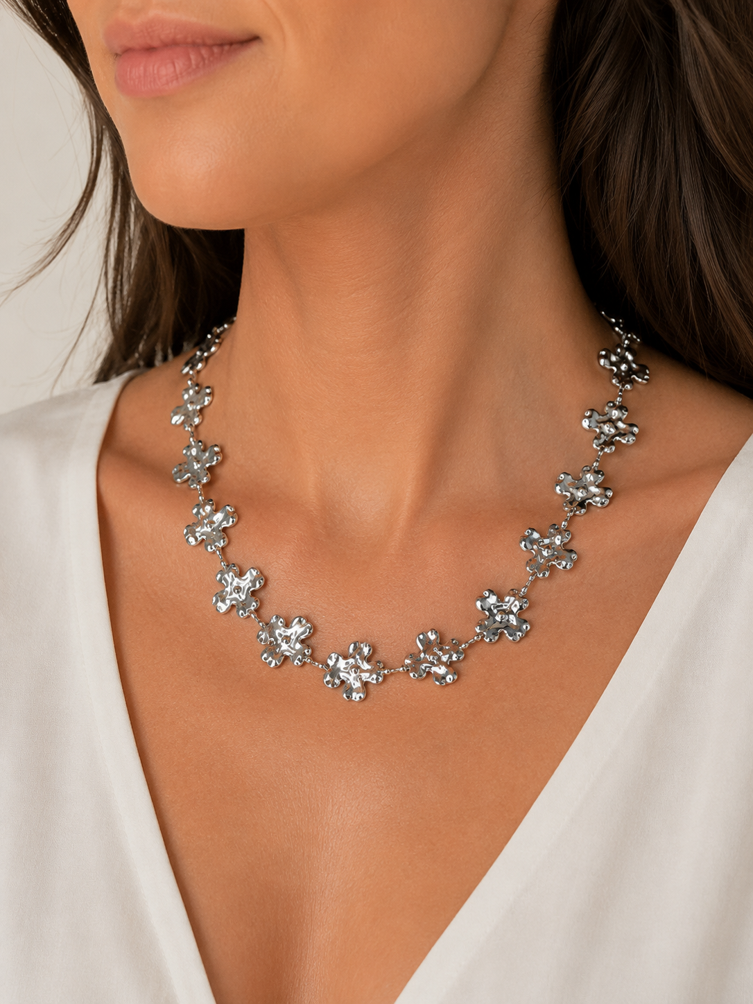 Modelo llevando el Collar Fiorella plateado con flores irregulares y acabado texturizado de BRAVATA.
