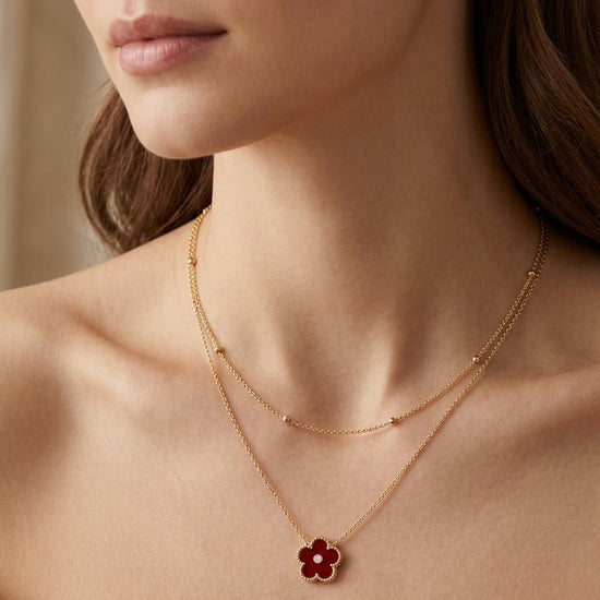 mujer con collar dorado doble cadena con colgante de flor roja elegante