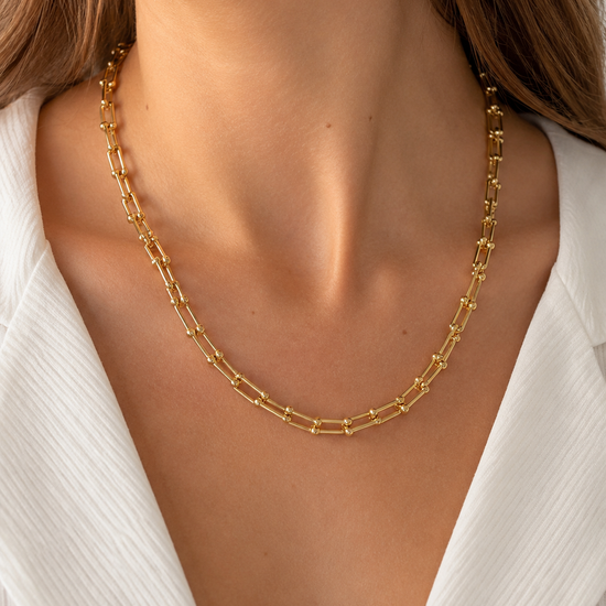 Modelo llevando el Collar Kael dorado con eslabones rectangulares de diseño geométrico de BRAVATA.