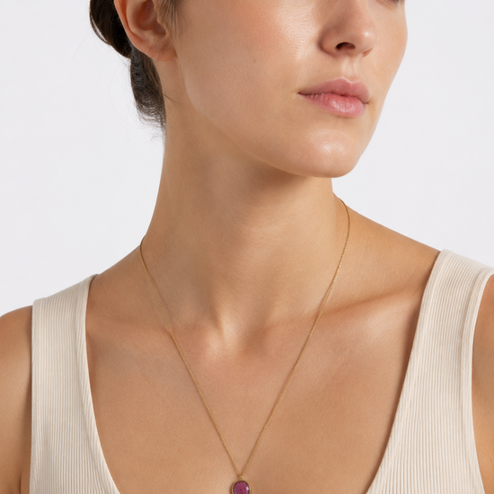 Modelo llevando el Collar Lúa dorado de cadena fina con colgante circular de piedra fucsia de BRAVATA.