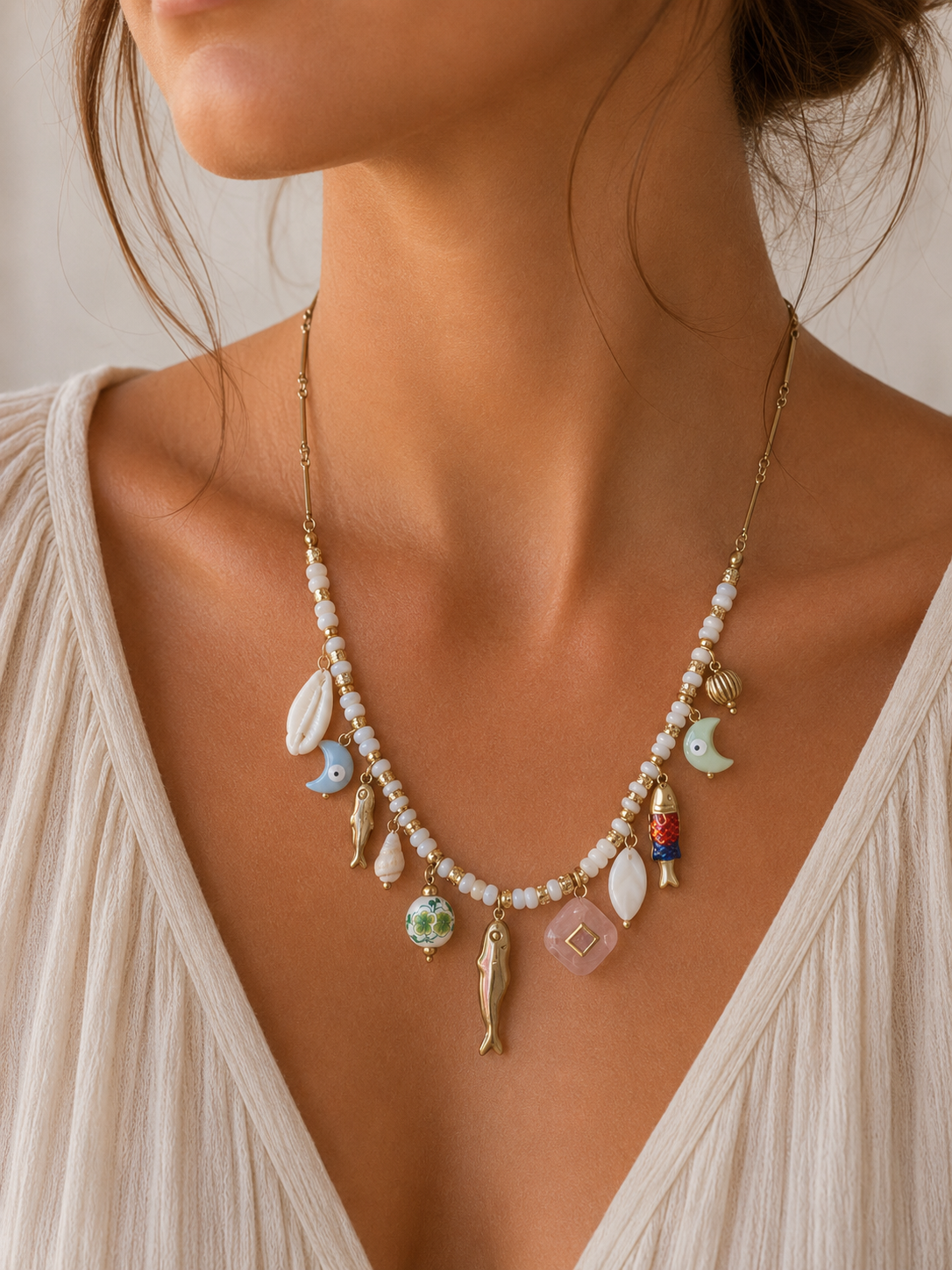 Mujer llevando collar marinero con charms de peces y conchas de BRAVATA
