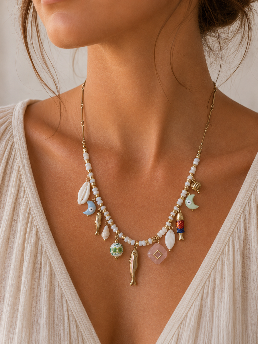 Mujer llevando collar marinero con charms de peces y conchas de BRAVATA