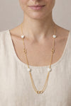 Mujer con collar largo dorado con corazones blancos estilo elegante