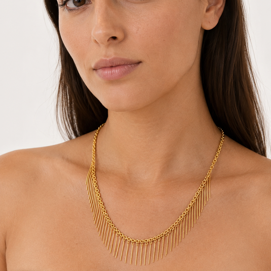 Modelo llevando el Collar Naira dorado con cadena fina y flecos colgantes de BRAVATA.