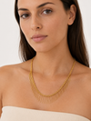 Modelo llevando el Collar Naira dorado con cadena fina y flecos colgantes de BRAVATA.