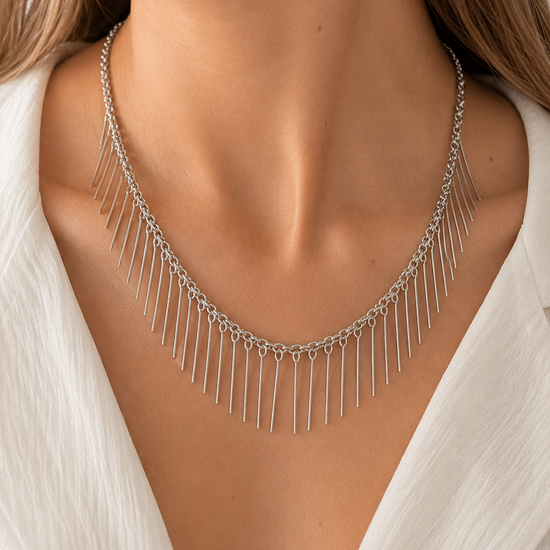Modelo llevando el Collar Naira plateado con cadena fina y flecos metálicos colgantes de BRAVATA.