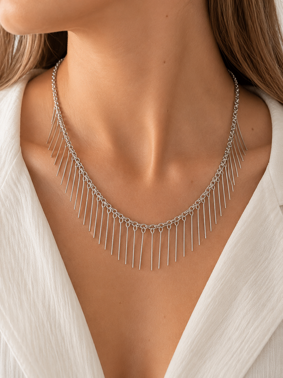 Modelo llevando el Collar Naira plateado con cadena fina y flecos metálicos colgantes de BRAVATA.