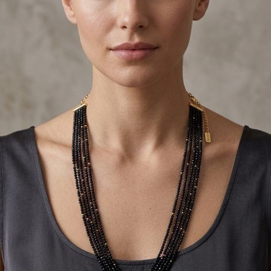 Collar negro de múltiples vueltas con cuentas finas y cierre dorado elegante