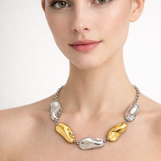 Mujer con collar Pebble bicolor de acero inoxidable en tonos dorado y plateado diseño orgánico elegante