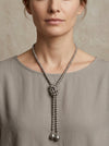 Collar largo de perlas con caída tipo lazo y detalles en forma de lágrima puesto en mujer estilo elegante Bravata