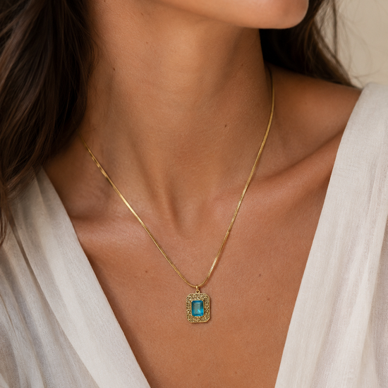 Mujer llevando collar dorado con piedra azul rectangular de BRAVATA
