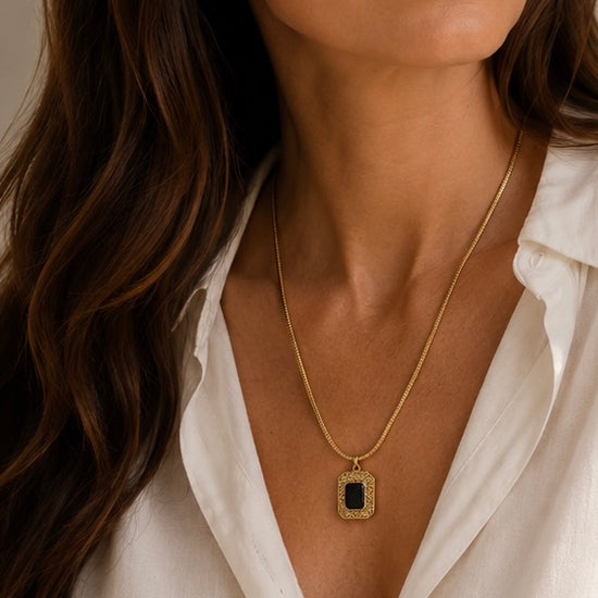 Mujer llevando collar dorado con piedra negra rectangular de BRAVATA