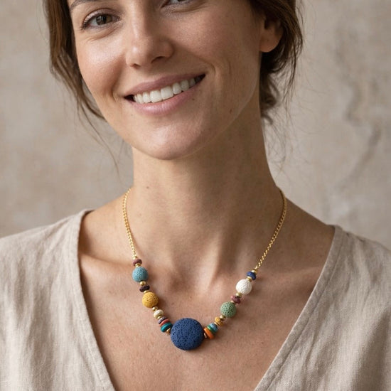 Mujer con collar de piedras volcánicas de colores y cadena dorada estilo natural y elegante
