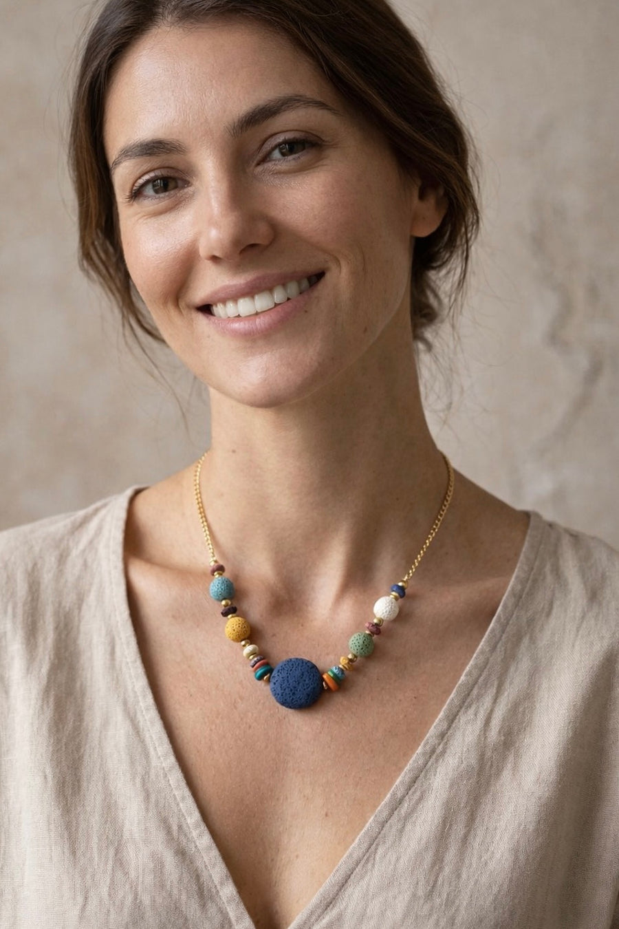 Mujer con collar de piedras volcánicas de colores y cadena dorada estilo natural y elegante
