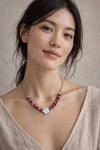 Mujer con collar plateado con cuentas rojas y detalle de flor diseño elegante y moderno