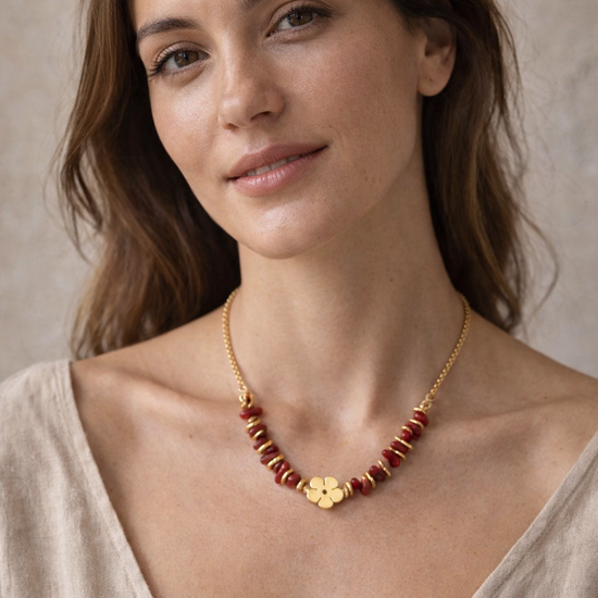 Mujer con collar rojo y dorado con detalle de flor diseño elegante y femenino