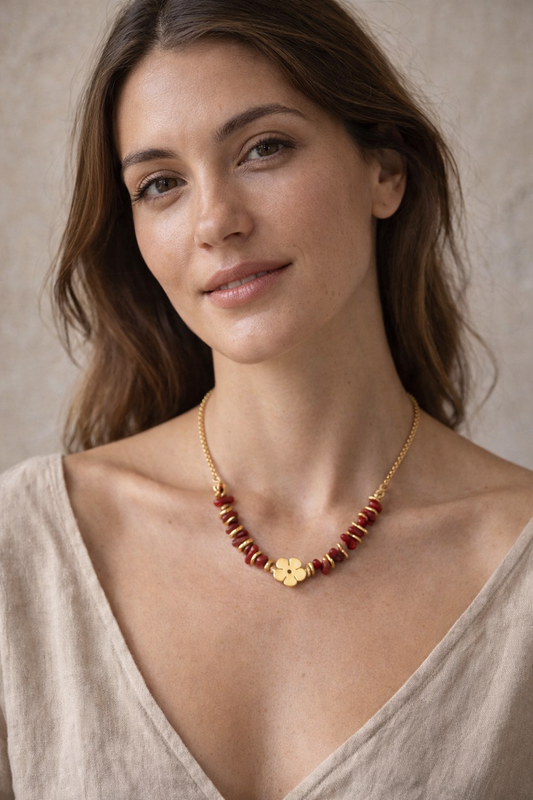 Mujer con collar rojo y dorado con detalle de flor diseño elegante y femenino