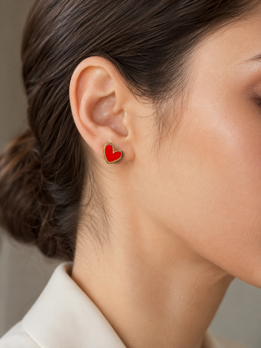 Mujer luciendo los Pendientes Corinne dorados con corazón rojo