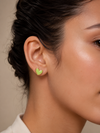 Mujer luciendo los Pendientes Corinne dorados con corazón verde lima